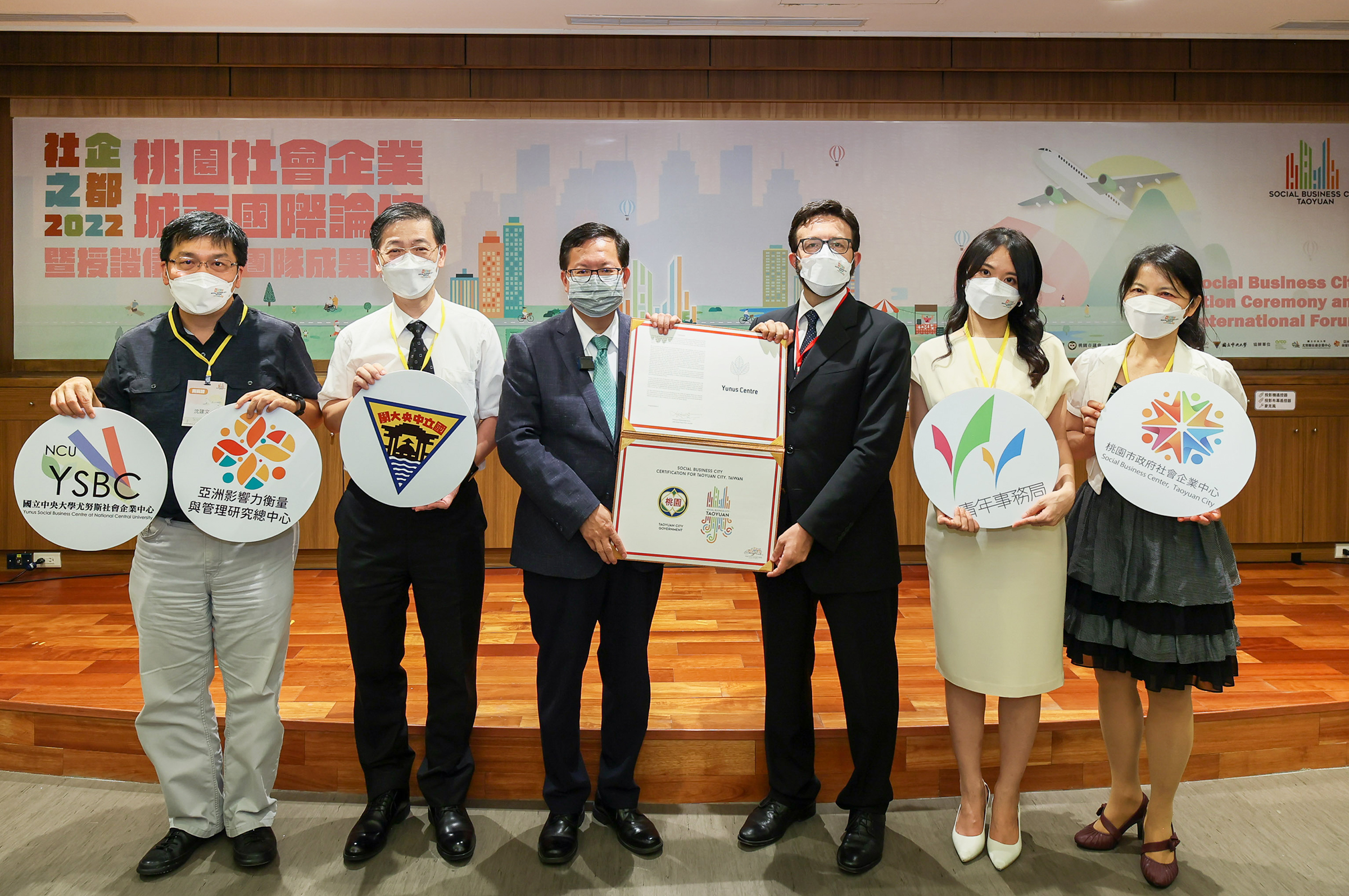 桃園市鄭文燦市長(左三)、社會企業城市授證代表義大利經貿文化推廣辦事處副主任Luigi Racine(右三)、中央大學綦振瀛副校長(左二)、尤努斯社會企業中心沈建文主任(左一)於授證儀式合照。照片尤努斯社會企業中心提供