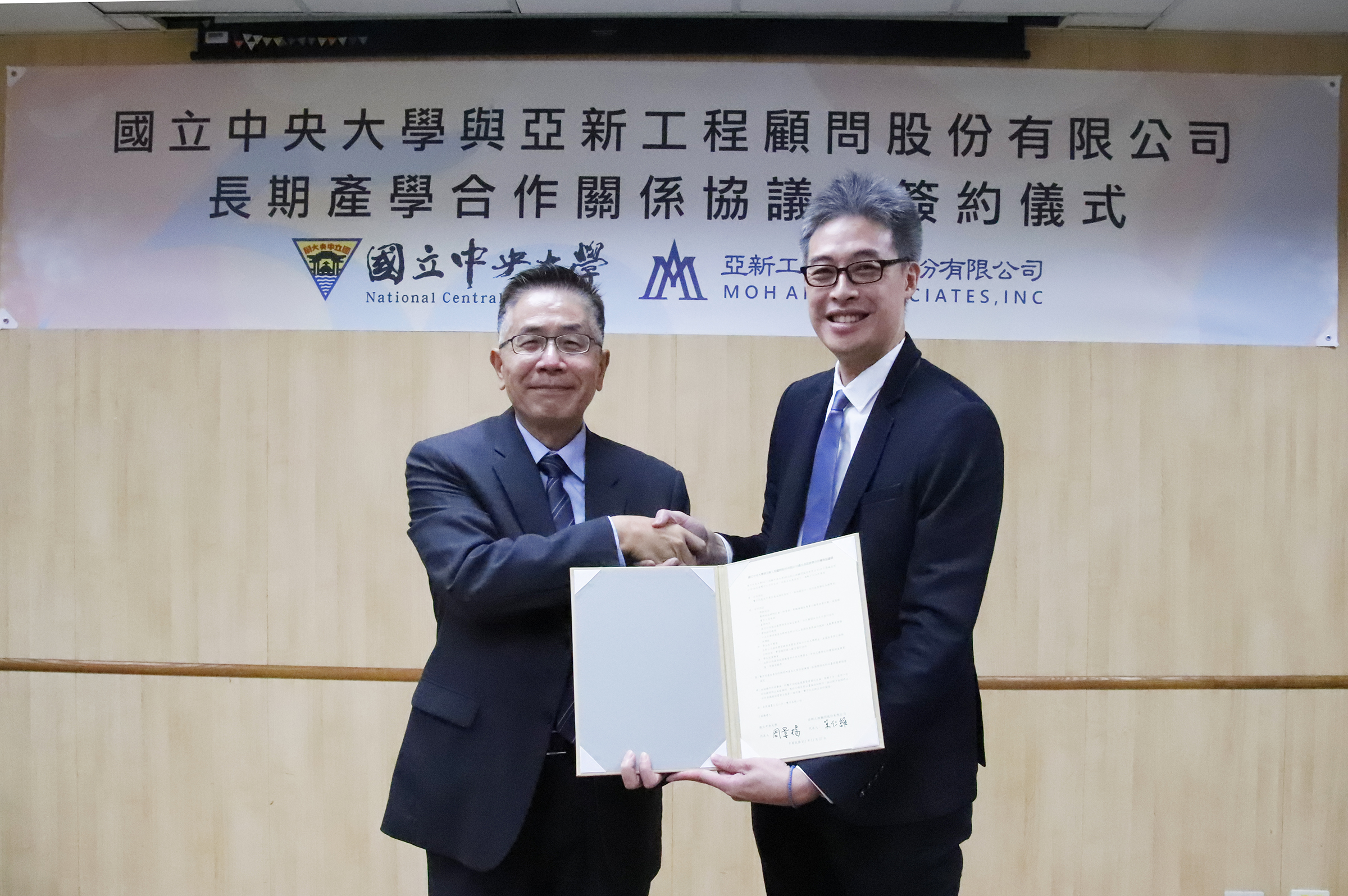 國立中央大學周景揚校長(左)與亞新工程顧問公司莫仁維董事長(右)簽署產學合作協議書。陳如枝攝
