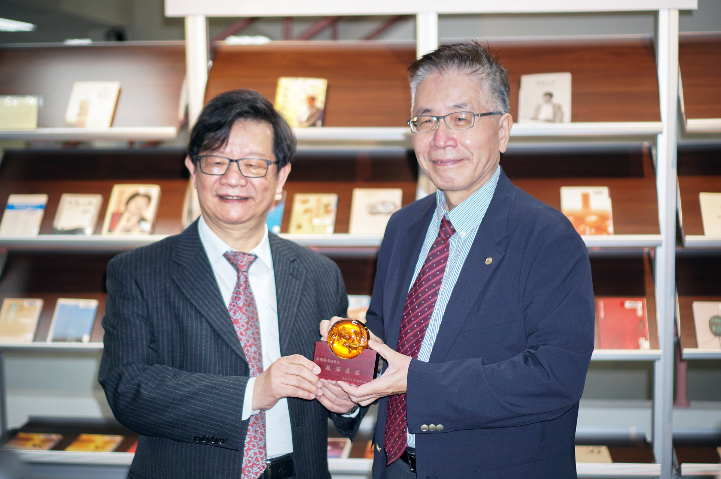 中央大學周景揚校長(右)向李瑞騰教授(左)致上感謝之意,感謝他對中大的全然奉獻。照片人文藝術中心提供