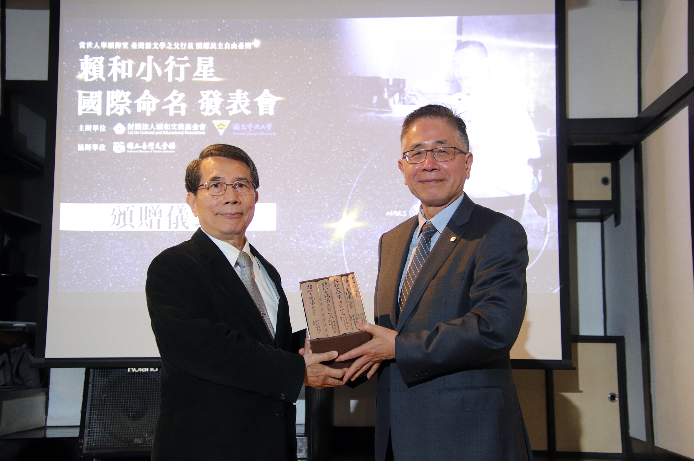 賴和文教基金會董事長吳潮聰（左）致贈中央大學賴和手稿影像集，由校長周景揚（右）代表接受。
