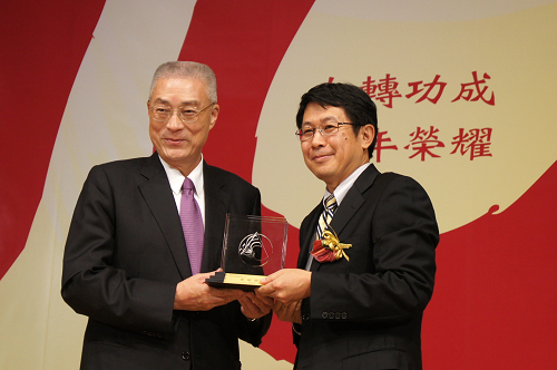 中央大學蔣偉寧校長(右)從行政院長吳敦義(左)手中獲頒第九屆金檔獎。陳如枝攝