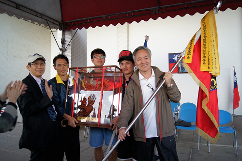 資管系從校長蔣偉寧(左一)手中獲頒大會總錦標，系主任何靖遠(右一)揮舞著勝利旗。陳如枝攝
