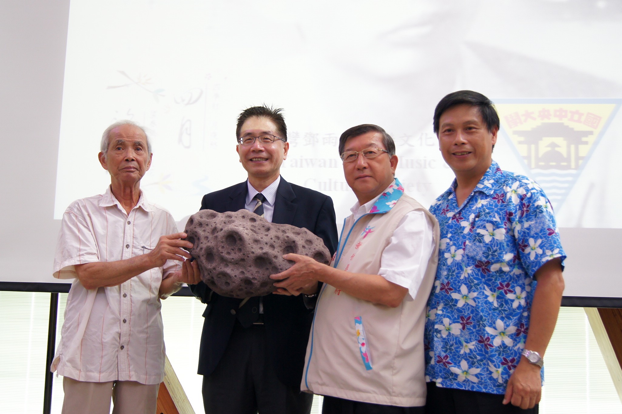 中央大學校長周景揚（左二）頒贈「鄧雨賢小行星」模型給新竹縣長邱鏡淳（右二）和鄧雨賢次子鄧仁侃先生（左一），以感念這位台灣民謠先驅。陳如枝攝