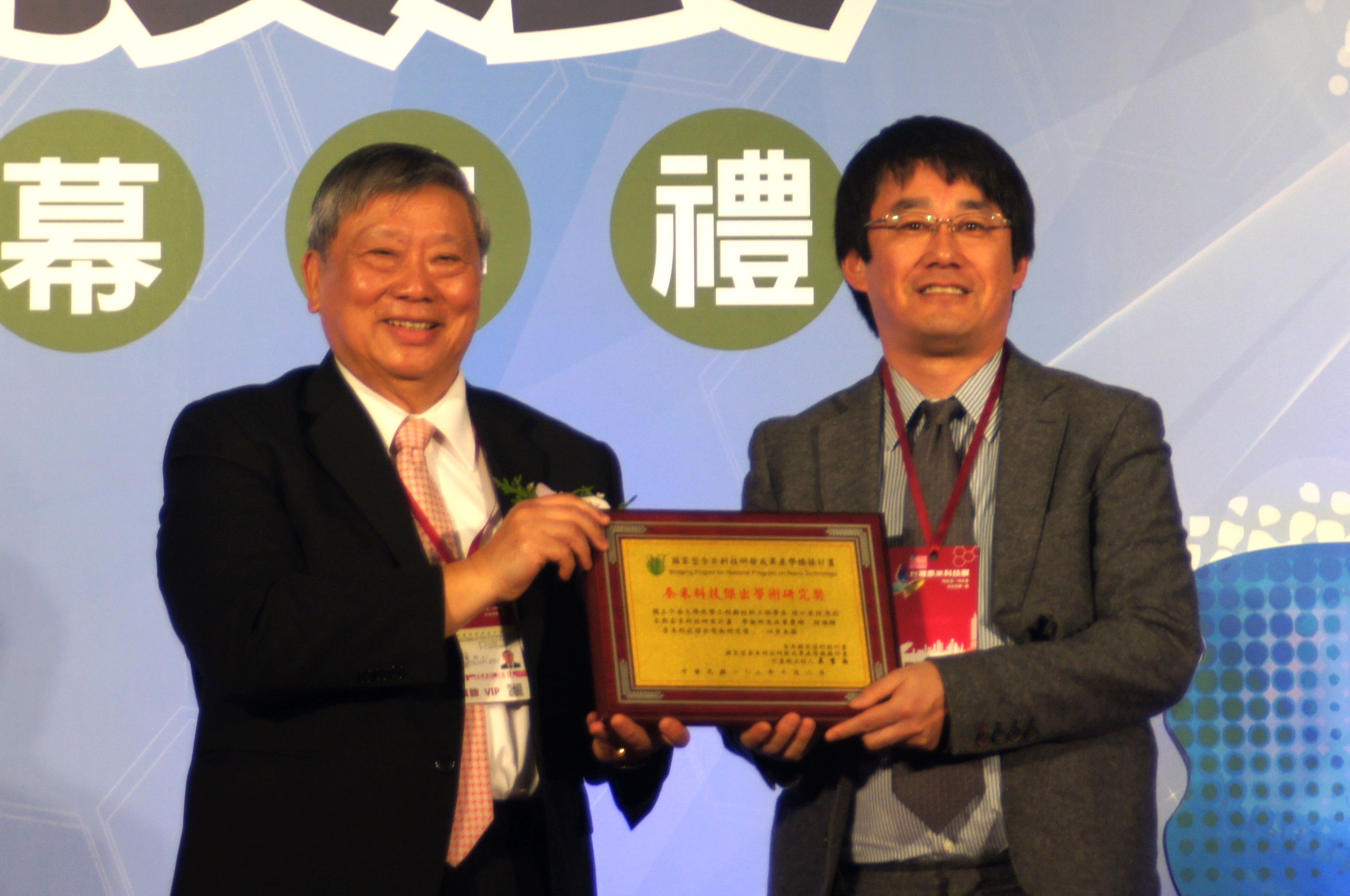 本校化材系樋口亞紺教授(右),在台北世貿中心獲頒「奈米科技傑出貢獻獎」,由計畫總主持人吳重雨(左)頒獎。陳上琳攝