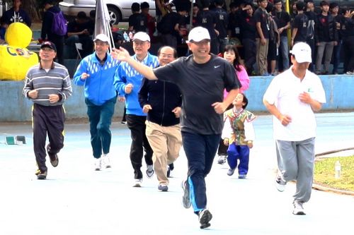 中央大學校長周景揚在運動會開幕式中引領一級主管帶動跑，受到師生熱情加油！陳文龍攝