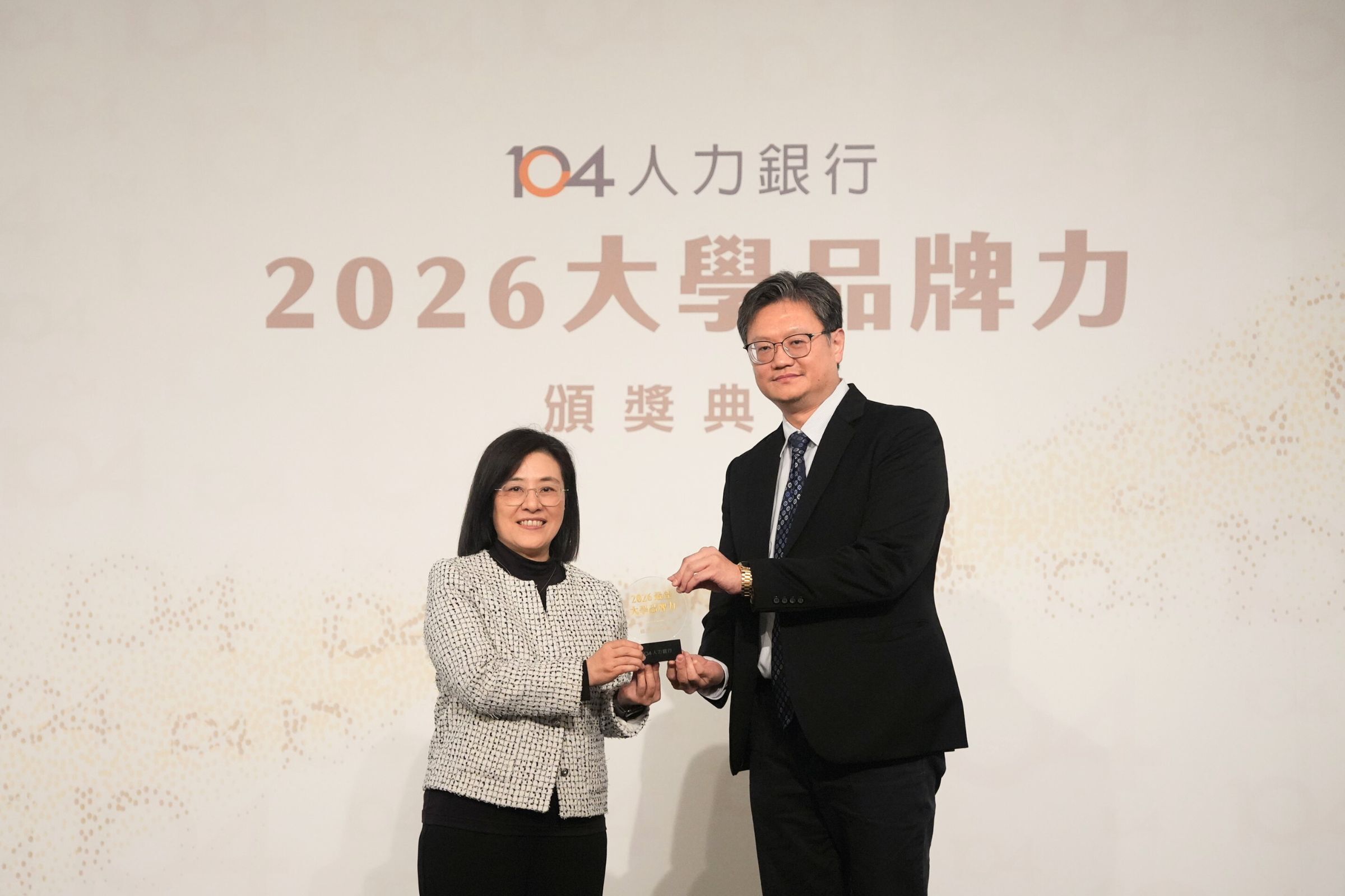 104人力銀行頒發的2026大學品牌力，中央大學主任秘書李宇翔（右）從104人力銀行黃于純總經理（左）手中接獲獎項。陳如枝攝