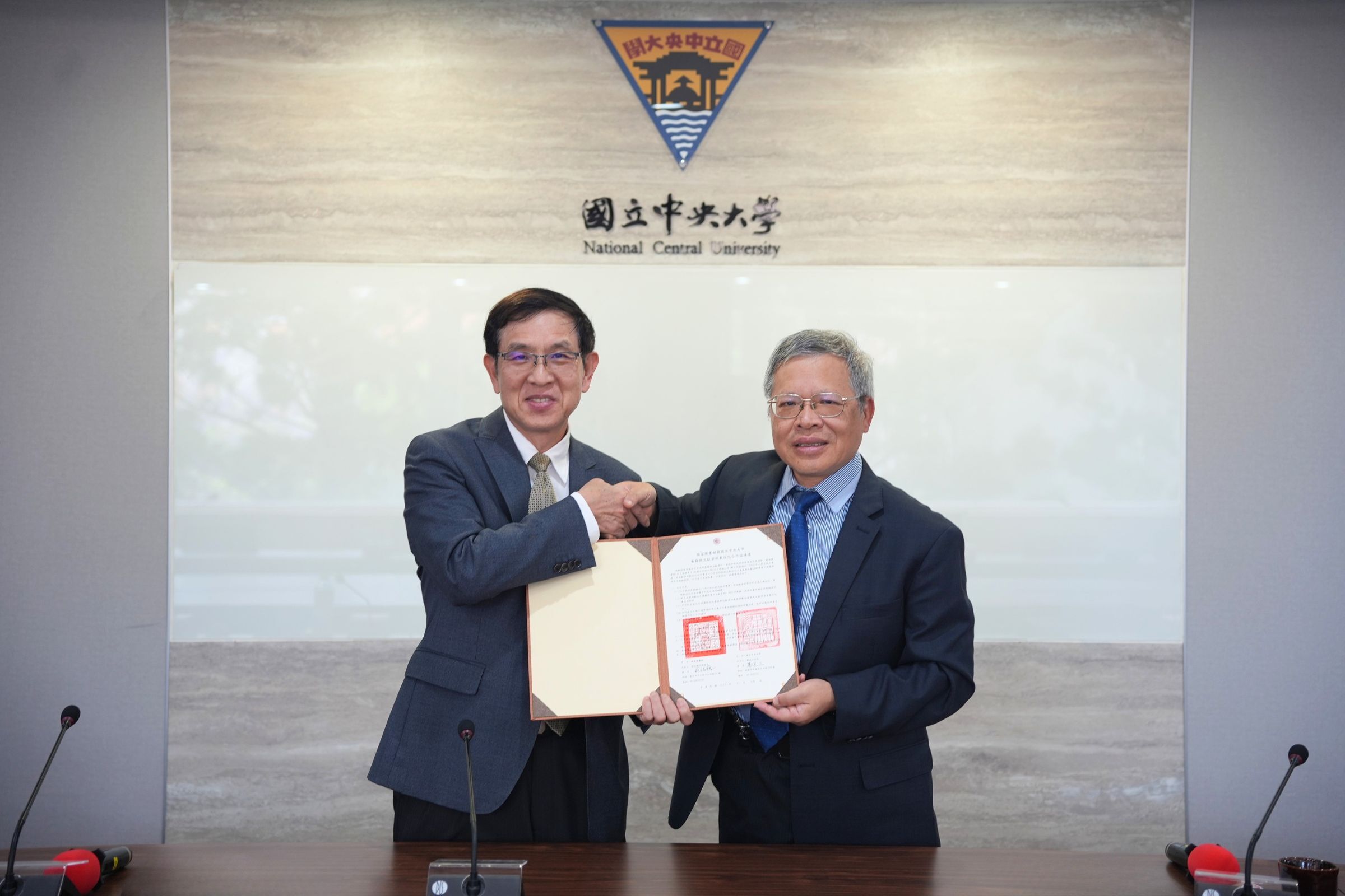 中央大學校長蕭述三(右)與國家圖書館代理館長翁誌聰（左）共同簽署合作，一同為歷史文獻活化而努力。陳如枝攝